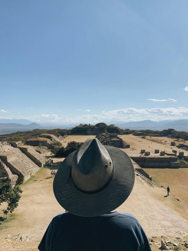 A tourist with a hat enjoys a clear day at Monte Albán, Oaxaca, Mexico.