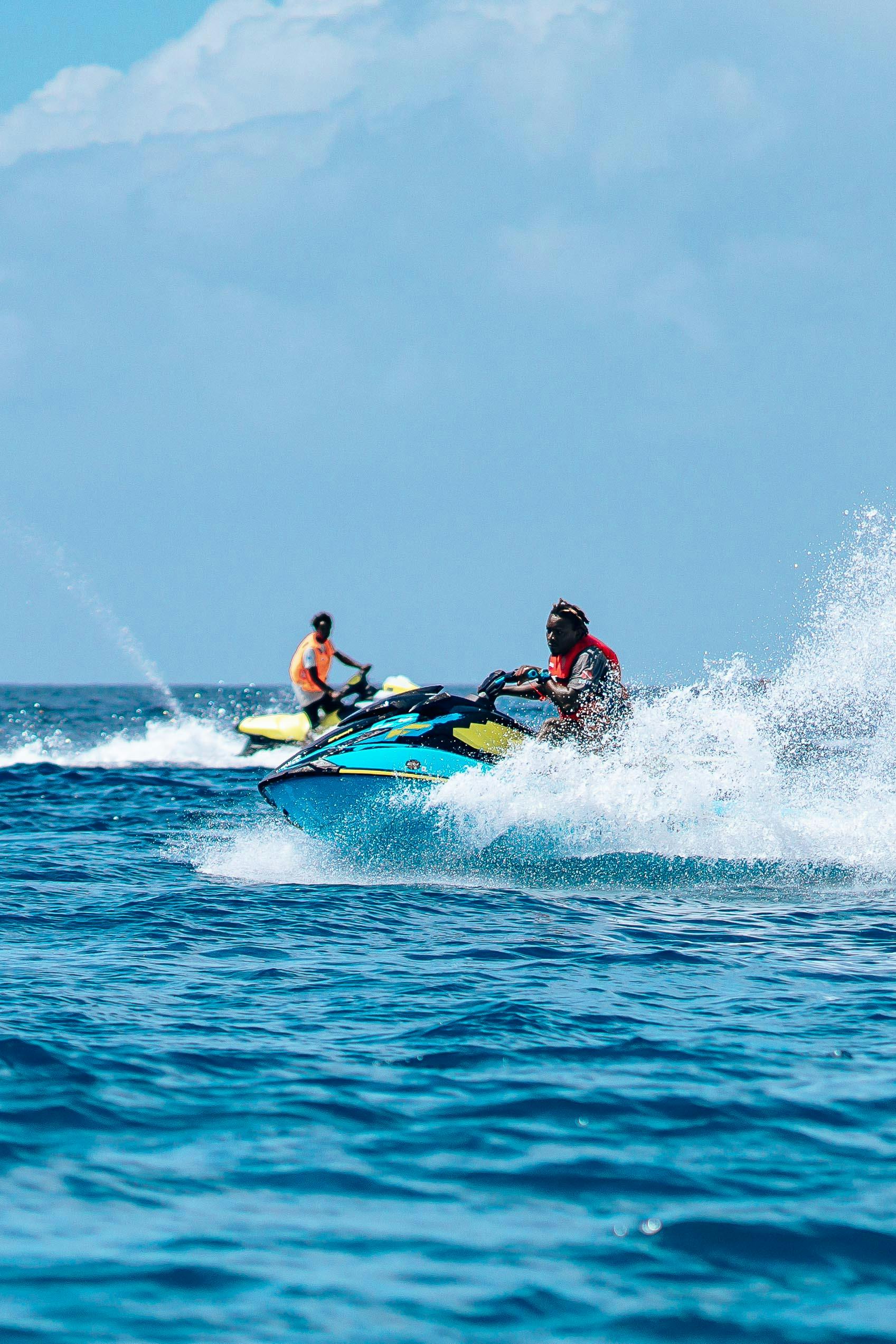 Services Two adults enjoy an exhilarating jet ski ride, capturing the thrill of sea adventure and speed.