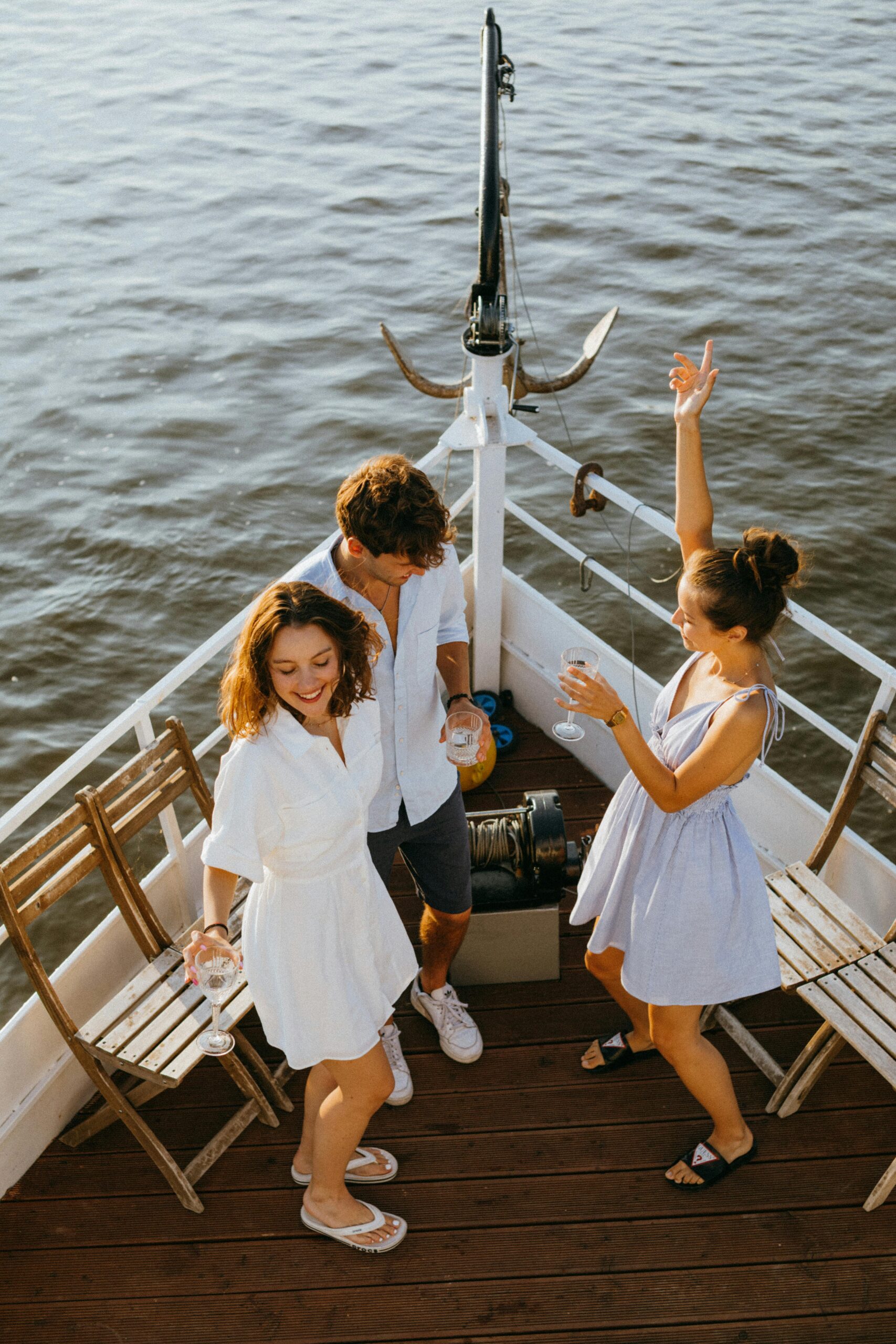 Services Three friends enjoying a sunny day dancing on a yacht