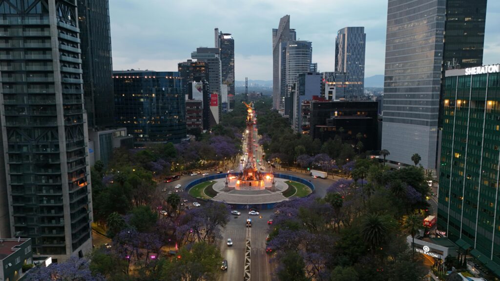 Services Stunning aerial view of Reforma Avenue with skyscrapers and Jacaranda trees in Mexico City.